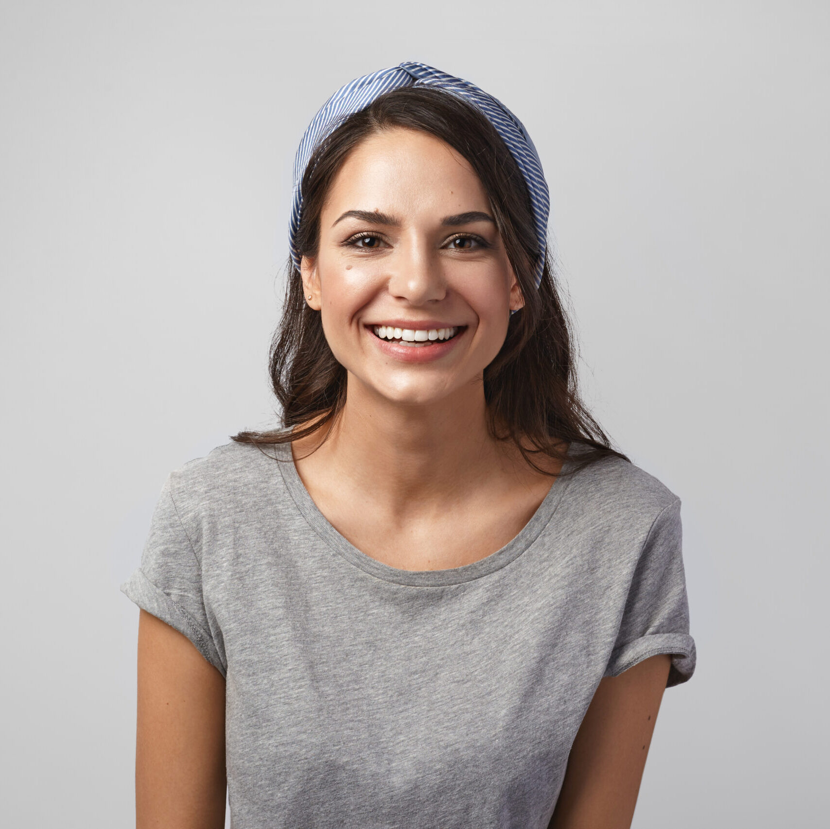 Positive human facial expressions, emotions, reaction and life perception. Isolated shot of cheerful joyful young dark haired lady enjoying great news, looking at camera with happy broad smile Positive human facial expressions, emotions, reaction and life perception. Isolated shot of cheerful joyful young dark haired lady enjoying great news, looking at camera with happy broad smile